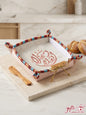 Embroidered Ahlan Wa Sahlan fabric bread basket with traditional trim and wooden spreader