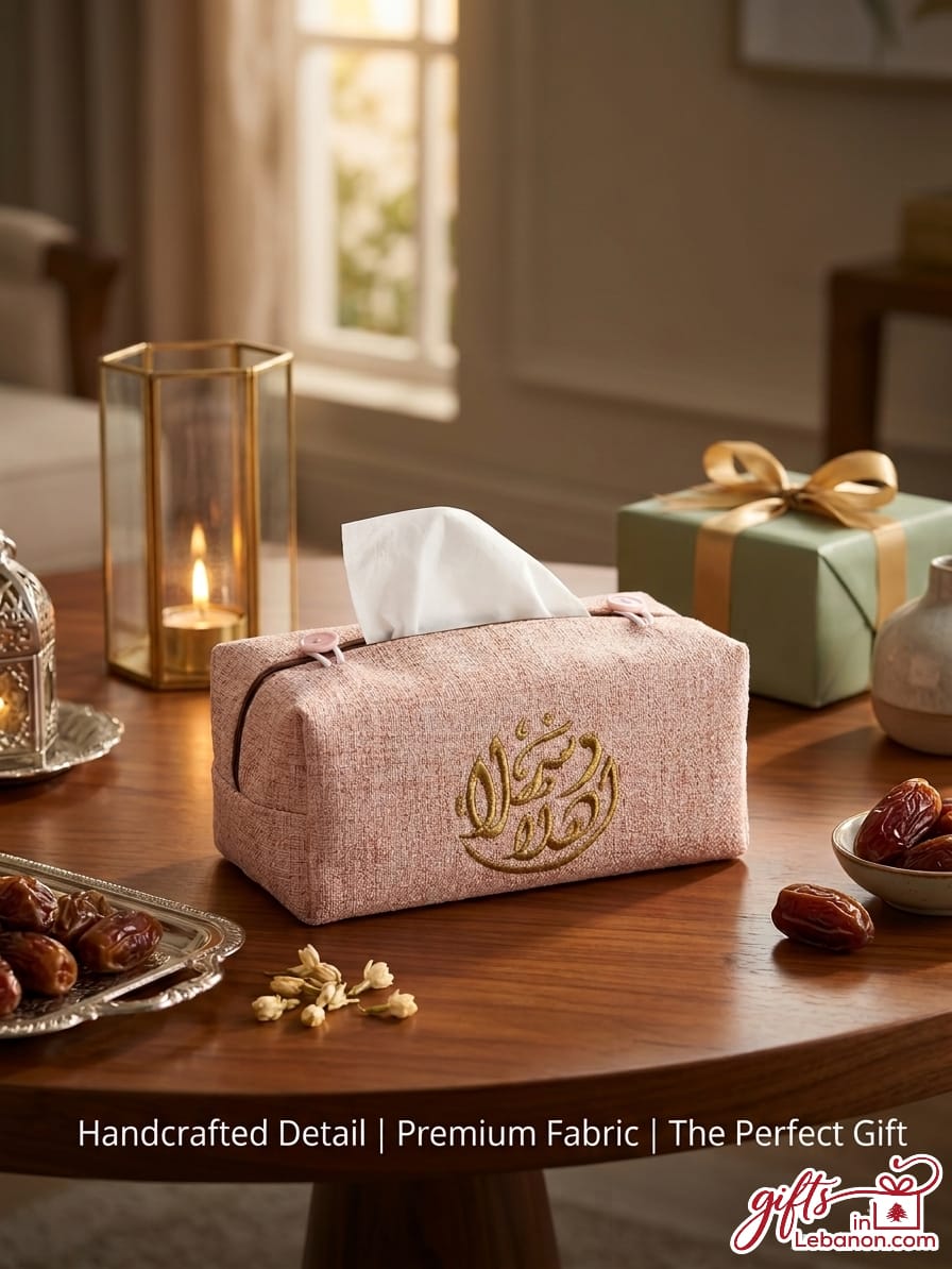 Handcrafted dusty rose tissue box cover with gold Arabic calligraphy embroidery on a wooden table