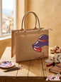 Hand-painted natural jute tote bag with a chic woman in a purple hat design