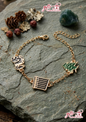 Gold-plated Lebanese charm bracelet with Cedar tree and Arabic calligraphy charms on a stone background