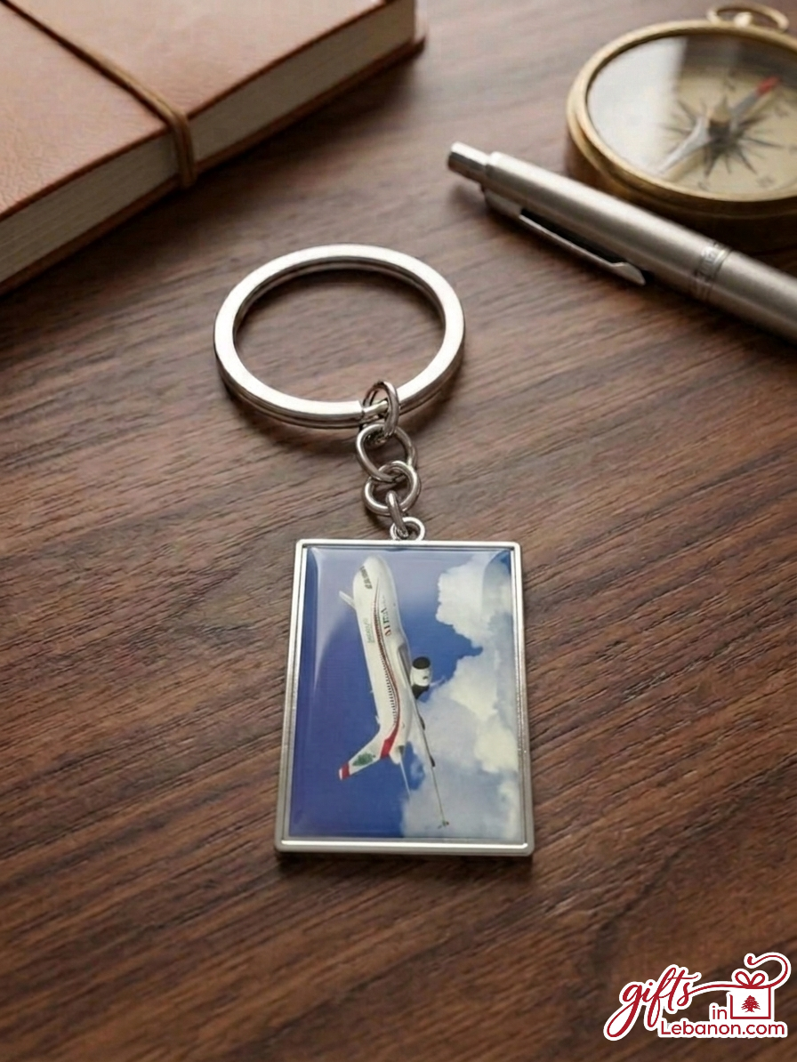 Rectangular metal keychain featuring a Middle East Airlines MEA airplane flying in the sky