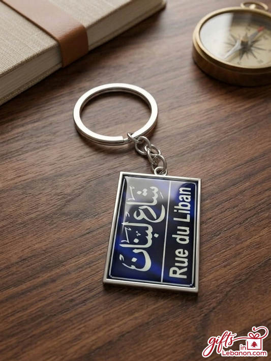 Rue du Liban blue street sign keychain on a wooden table